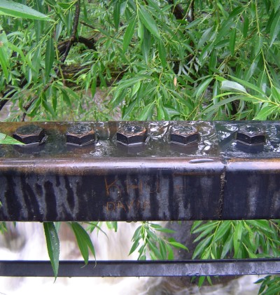 rain on bridge railing over boulder creek